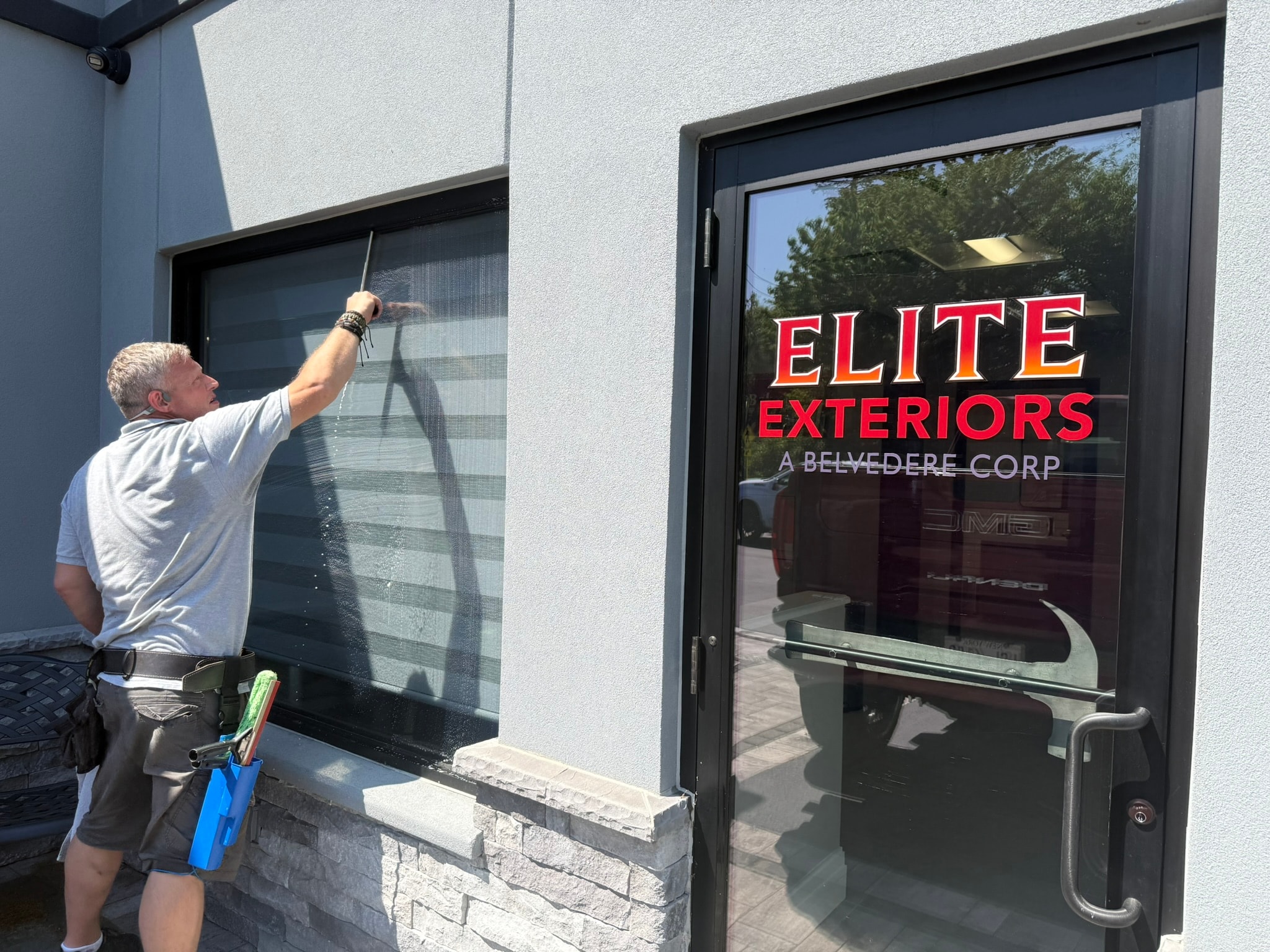 Worker cleaning window screen exterior
