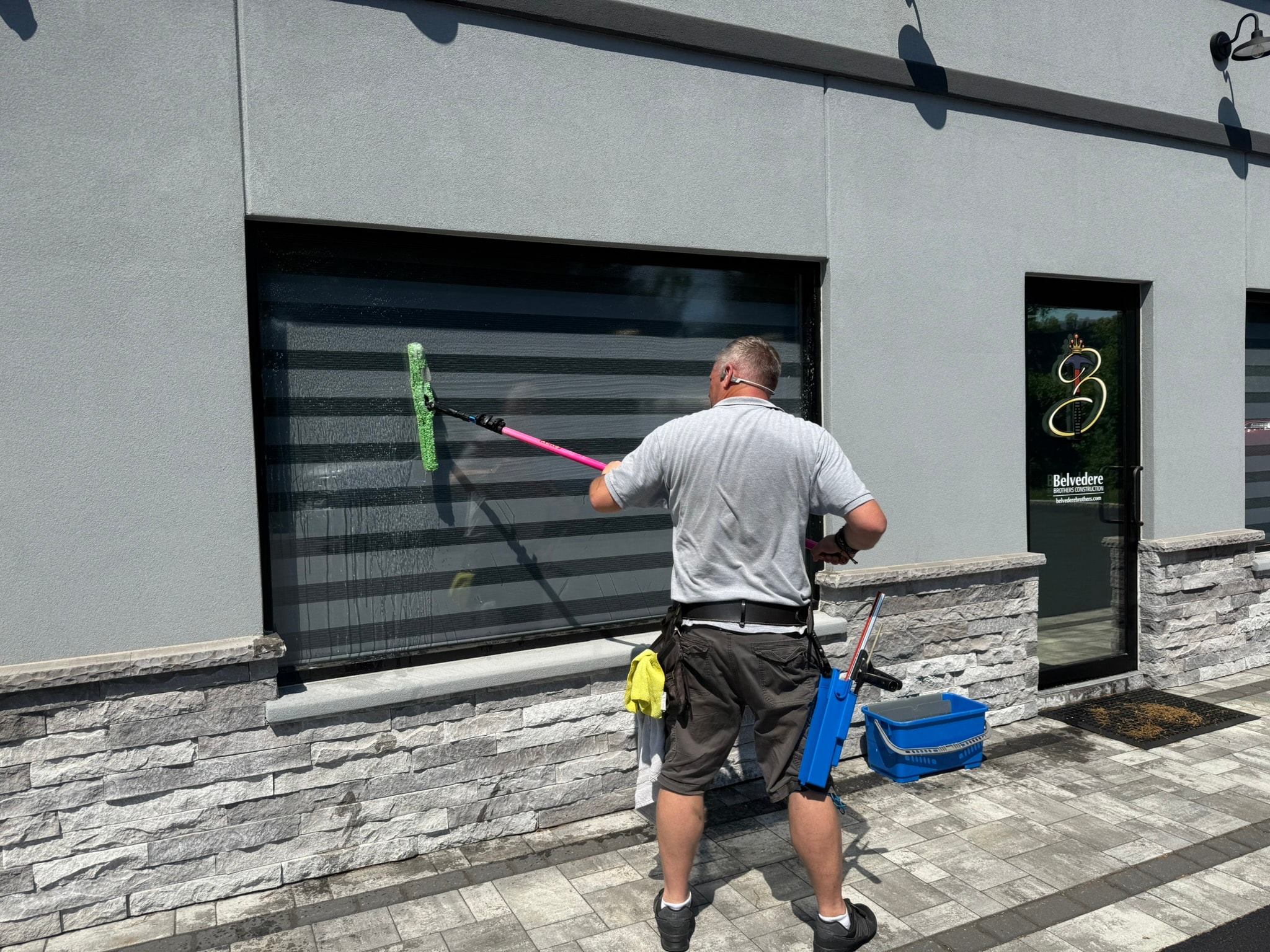 Worker cleaning garage door with brush