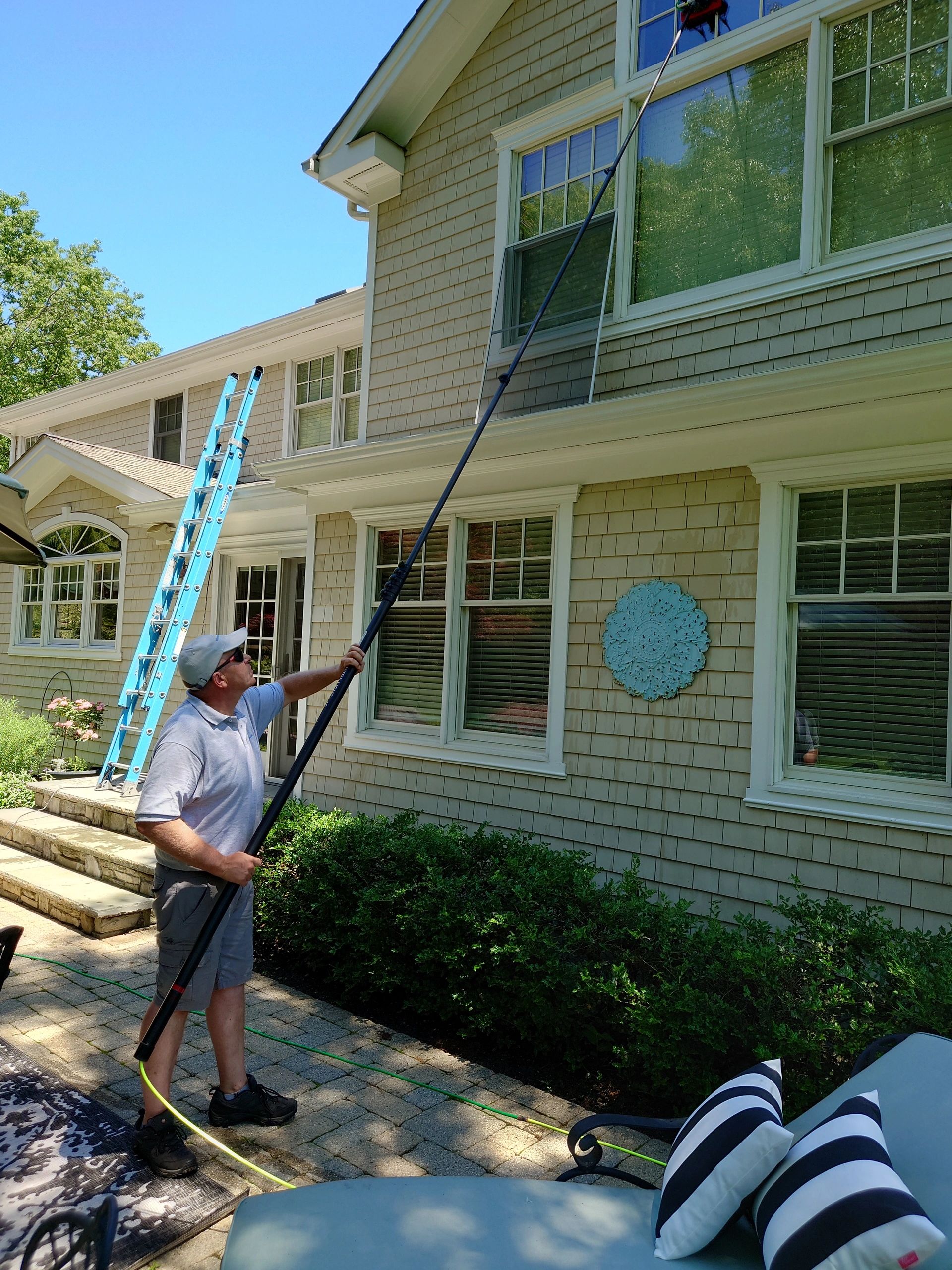 Pete cleaning windows on a Long Island home